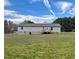 Backyard view of the home showcasing gray siding and a small wooden back porch at 349 Tristen Ln, Henderson, NC 27537