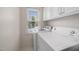 Bright laundry room features a stacked washer and dryer, white cabinets, and natural light from the window at 3529 Elk St, Burlington, NC 27215