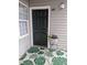 Home's charming entryway with a six-panel black door, leafy rug, and decorative flower pot at 3710 Pardue Woods Pl # 103, Raleigh, NC 27606