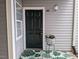 Charming entryway with a six-panel black door, leafy rug, and decorative flower pot at 3710 Pardue Woods Pl # 103, Raleigh, NC 27606