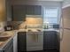 Well-lit kitchen with updated appliances, gray cabinets, and stylish countertops at 3710 Pardue Woods Pl # 103, Raleigh, NC 27606