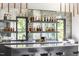 Close up on the bar area with liquor bottle displays, sink, faucet and a view to the backyard at 4300 Camelot Dr, Raleigh, NC 27609