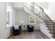Bright foyer features hardwood floors, a staircase with iron railings, and two comfortable chairs at 4300 Camelot Dr, Raleigh, NC 27609
