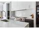 Modern kitchen features white cabinets, stainless steel range, and marble countertops at 4300 Camelot Dr, Raleigh, NC 27609
