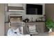 Modern outdoor kitchen with stainless steel grill, TV, and comfortable seating area at 4300 Camelot Dr, Raleigh, NC 27609