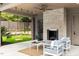 Covered patio with a stone fireplace, swing seats, ceiling fan, and comfortable seating at 4300 Camelot Dr, Raleigh, NC 27609