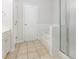 Bright bathroom with a tiled floor, soaking tub, and glass shower at 4308 Brynwood Ave, Durham, NC 27713