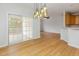 Bright dining area featuring wood floors, unique lighting, and sliding door access to a covered porch at 4308 Brynwood Ave, Durham, NC 27713