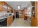 Spacious kitchen with oak cabinetry, black appliances, tile flooring, and ample counter space at 4316 Old Faison Rd, Knightdale, NC 27545