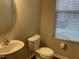 Half bathroom with pedestal sink, elongated toilet, and natural light from window at 4469 Middletown Dr, Wake Forest, NC 27587