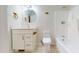 A bright bathroom with a white vanity, round mirror, and a shower-tub combo at 4604 Sweet Melody Ln, Knightdale, NC 27545