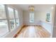 Dining room with bright windows, hardwood floors, modern chandelier, and bar seating at 4604 Sweet Melody Ln, Knightdale, NC 27545