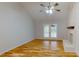 Bright living room featuring hardwood floors, a ceiling fan, fireplace, and doors to the backyard at 4604 Sweet Melody Ln, Knightdale, NC 27545