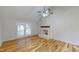 Bright living room featuring hardwood floors, white brick fireplace, and glass doors to a patio at 4604 Sweet Melody Ln, Knightdale, NC 27545