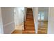 View of hardwood staircase with an ornate iron handrail, leading up from the entry area at 4604 Sweet Melody Ln, Knightdale, NC 27545