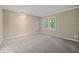 This carpeted bedroom features neutral walls and trim and a window with lots of natural light at 502 Forest Court, Carrboro, NC 27510