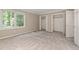 Bright bedroom with neutral carpet, trim, walls and featuring two closets and a window at 502 Forest Court, Carrboro, NC 27510