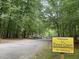 Welcome to Forest Court neighborhood sign with trees, cars, and road at 502 Forest Court, Carrboro, NC 27510