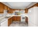 Kitchen boasts wood cabinets, tile floors, and white appliances for cooking and storage at 502 Forest Court, Carrboro, NC 27510