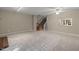Spacious living room with neutral walls, carpet, ceiling fan and stairs to the upper level at 502 Forest Court, Carrboro, NC 27510