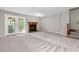 Spacious carpeted living room with a fireplace, double glass doors and staircase at 502 Forest Court, Carrboro, NC 27510