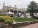 Brick mansion with people and trees on a green lawn with a stone wall at 502 Forest Court, Carrboro, NC 27510