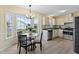 Eat-in kitchen features stainless appliances, white cabinets, and a bay window with table and chairs at 509 Yellow Berry, Wendell, NC 27591