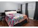 Bedroom with gray walls, wood floors, two windows with blinds and black curtains, and a gray platform bed at 543 Pine Ridge Place, Raleigh, NC 27609