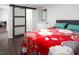 Bedroom boasts wood floors, a sliding barn door to the bathroom, and a red floral-patterned bedspread at 543 Pine Ridge Place, Raleigh, NC 27609