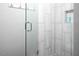 Walk-in shower featuring white tile, glass doors, pebble-style floor and niche at 543 Pine Ridge Place, Raleigh, NC 27609