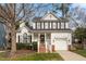 Charming two-story white home with black shutters, landscaped front yard, and attached garage on a sunny day at 5704 Edgebury Rd, Raleigh, NC 27613