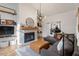 Bright living room with gray sectional, leather ottoman, and decorative fireplace with mantel and shelves at 5704 Edgebury Rd, Raleigh, NC 27613