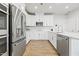 Bright kitchen featuring stainless steel appliances, white cabinetry, and a large island with quartz countertops at 600 Hedrick Ridge Road # 108, Cary, NC 27519