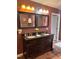 Bathroom featuring double sinks, dark cabinets, large mirrors, and updated tile at 601 Aiken Pkwy, Fuquay Varina, NC 27526