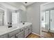 Modern bathroom with double sinks, quartz countertops and gray cabinets at 604 Chadbourne Dr, Durham, NC 27703
