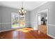 Dining room featuring hardwood floors, white trim, gray walls, and chandelier lighting fixture with an open floorplan at 604 Chadbourne Dr, Durham, NC 27703