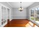 Elegant dining room with a chandelier, hardwood floors, white trim, and large windows with bright lighting at 604 Chadbourne Dr, Durham, NC 27703