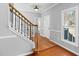 Inviting home foyer featuring hardwood floors, white trim, staircase, and a front door with natural lighting at 604 Chadbourne Dr, Durham, NC 27703