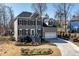 Charming two-story home with a well-manicured front yard, black shutters, and an attached two-car garage at 604 Chadbourne Dr, Durham, NC 27703
