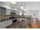 Updated kitchen features granite counters, stainless steel appliances, backsplash, island, and open floor plan at 604 Chadbourne Dr, Durham, NC 27703