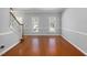 Bright living room features wood floors, neutral walls, staircase, and two large windows with bright light at 604 Chadbourne Dr, Durham, NC 27703