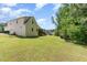 View of the home's side and backyard, with lush green grass and trees at 70 Breadnut Dr, Smithfield, NC 27577