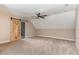 Spacious bedroom with neutral carpet, fan, and sliding barn door to another room at 70 Breadnut Dr, Smithfield, NC 27577