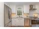 Modern kitchen featuring white cabinets, stainless steel appliances, granite countertops, and ample natural light at 7017 Sandringham Ct, Raleigh, NC 27613