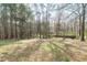 Large, partially wooded backyard with grass, fallen leaves, and a wooden fence at 773 Rebecca Ln, Siler City, NC 27344