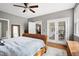 Bedroom with a wicker bed with white bedding, a ceiling fan, and french doors to the deck at 773 Rebecca Ln, Siler City, NC 27344