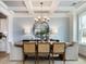 Dining room boasts modern chandelier, accent wallpaper and light wood floors at 95 Great Smoky Pl, Lillington, NC 27546