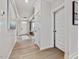 Bright hallway features white wainscoting, hardwood floors, and stylish light fixture at 95 Great Smoky Pl, Lillington, NC 27546
