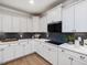 Bright kitchen featuring white cabinetry, quartz countertops, and dark backsplash with modern fixtures at 95 Great Smoky Pl, Lillington, NC 27546