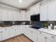 Gourmet kitchen with white cabinetry, quartz countertops, dark backsplash, and modern appliances at 95 Great Smoky Pl, Lillington, NC 27546